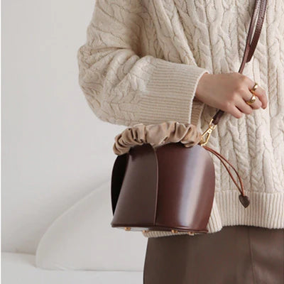 Eimer‑Handtasche aus braunem veganem Leder mit Rosenblatt‑Prägung, gerafftem Griff und herzförmigem Schnürzug‑Dekor
